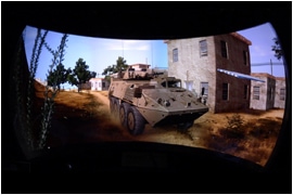Curved cylindrical display showing military vehicle simulation